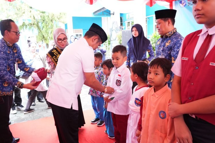 SIMBOLIS: Wali Kota Rahmad Mas'ud menyerahkan bantuan seragam sekolah gratis kepada siswa/i sekolah SD SMP Sederajat. (Doc. Humas Pemkot)