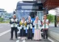 Petugas transportasi memberikan sambutan kepada pengunjung di depan bus listrik yang beroperasi di Kawasan Inti Pusat Pemerintahan (KIPP) Nusantara. (Dok. Humas Otorita IKN)